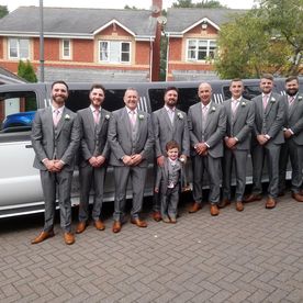 men posing near a limo ready to head to the wedding