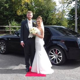 A couple outside of our baby black bentley